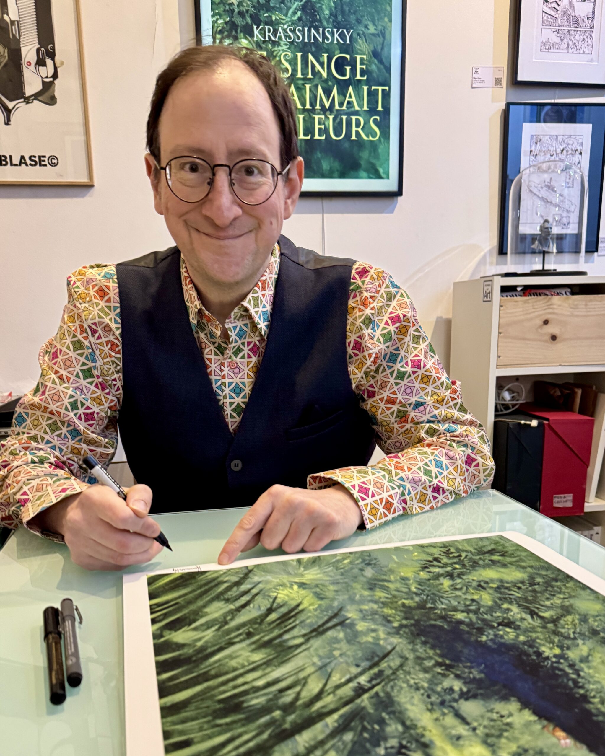 Jean Paul Krassinsky signant son print Le Singe qui Aimait les Fleurs à la galerie